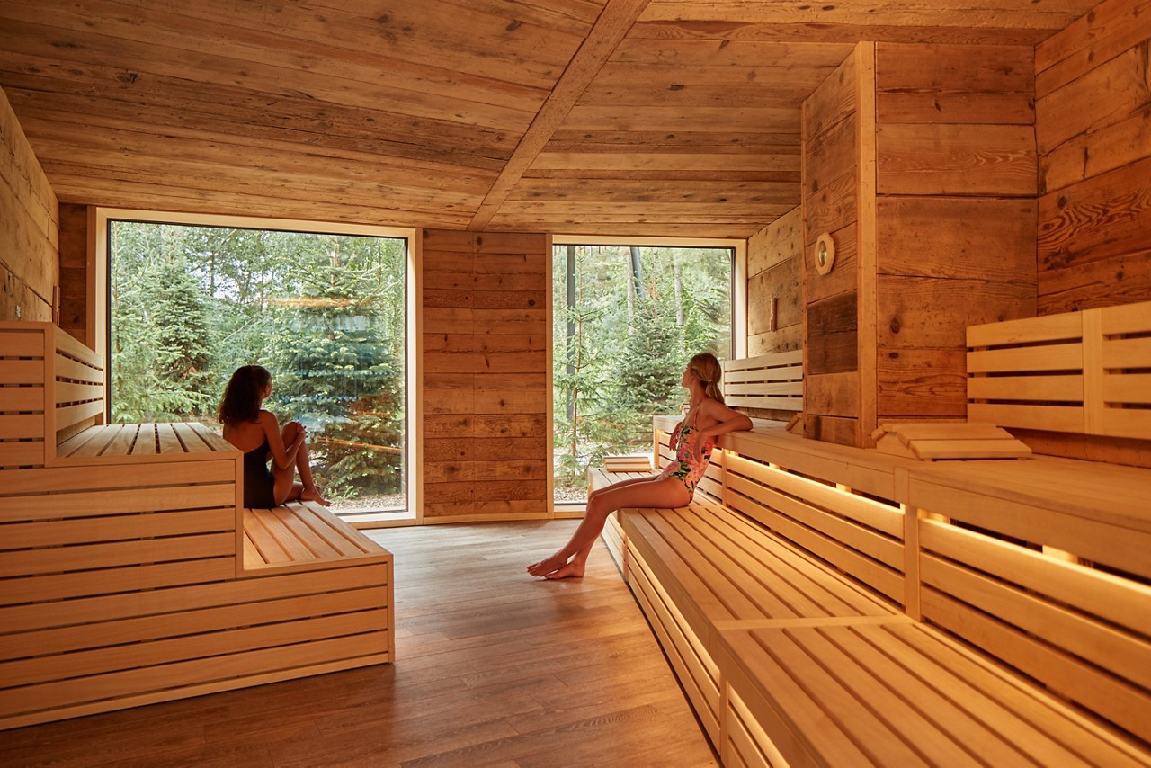Two ladies taking in the forest views as they enjoy the dry heat of the Nordic Sauna.